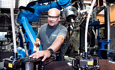 Sandvik Mining and Rock Technology: Man infront of robot arm (photo)