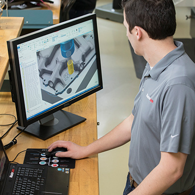 A man looking at a computer screen with CAM software (photo)