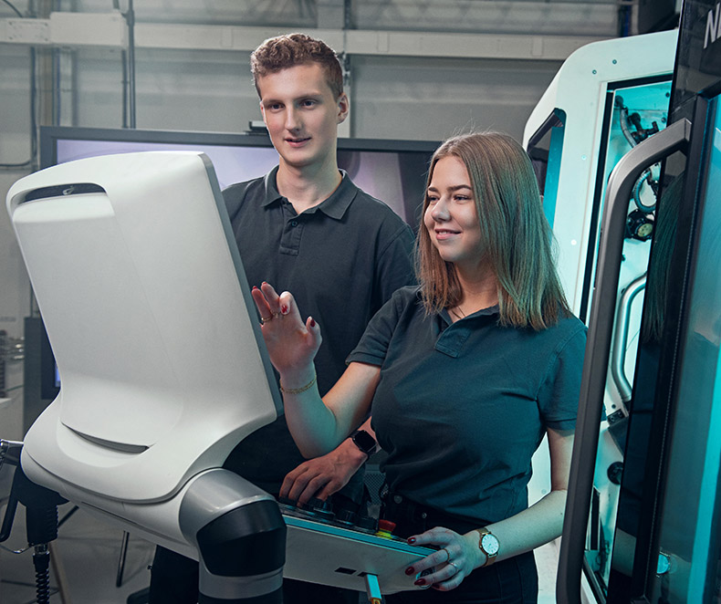 Man and woman looking at a machine control (photo)