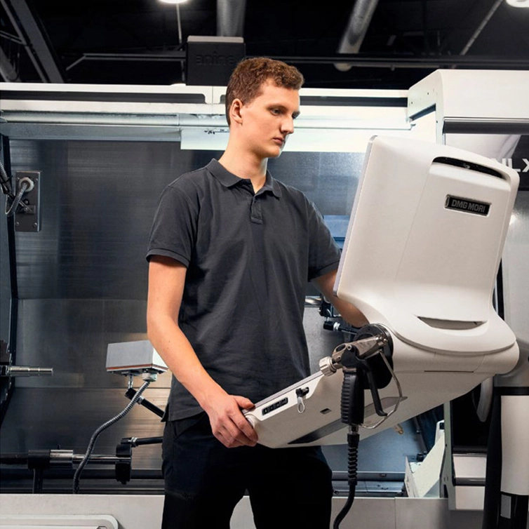 Man watching panel next to CNC machine (photo)